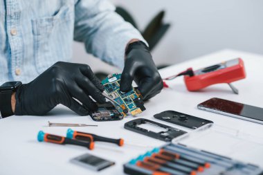 Teknisyen bozuk akıllı telefonu tamir ediyor. akıllı telefon servisi.