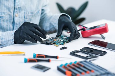 Teknisyen bozuk akıllı telefonu tamir ediyor. akıllı telefon servisi.