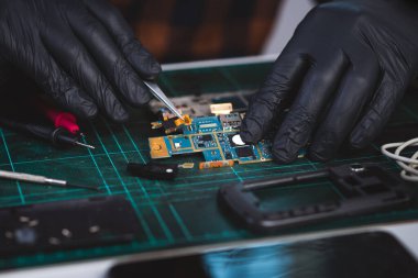 Teknisyen bozuk akıllı telefonu tamir ediyor. akıllı telefon servisi.