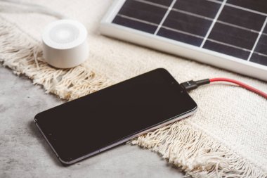 Akıllı telefonu güneş enerjisiyle şarj etmek. Yeşil enerji kavramı.