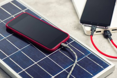 Akıllı telefonu güneş enerjisiyle şarj etmek. Yeşil enerji kavramı.