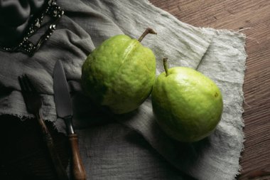 Masanın üzerinde koyu tonda yeşil Tayland guava meyvesi var..