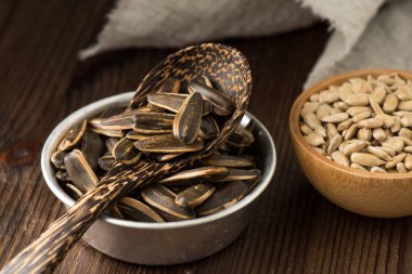 Kavrulmuş ay çekirdeği yığını ve arka planda dehulled tohumlar.. 