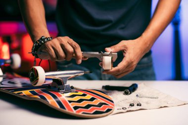 Adam kaykay tekerleğinin boyutunu ölçüyor. Yeni kaykay kurulumu kavramı.