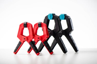 Plastik yay kıskacı beyaz arkaplanda izole edilmiş. Ahşap işçiliği, marangozluk ve diğer işler için ekipman.