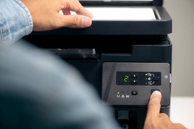 Ofiste çok fonksiyonlu lazer yazıcı kullanan adam..