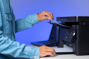 Ofiste çok fonksiyonlu lazer yazıcı kullanan adam..