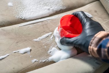 Araba koltuğunu köpük kimyasalla temizlemek, araba bakımı konsepti.