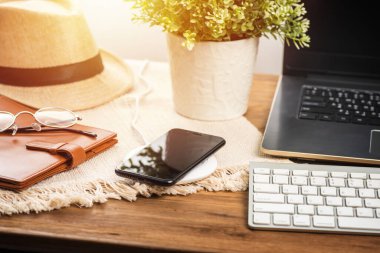 Akıllı telefonu ahşap masadaki kablosuz şarjla şarj etmek. Modern yaşam tarzı kavramı.