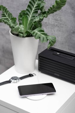Akıllı telefonu kablosuz şarj cihazıyla şarj etmek. Modern yaşam tarzı kavramı.