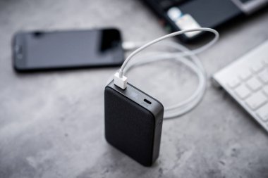 Güç bankasıyla çalışan akıllı telefon bataryası. Gri güç bankasına yakın plan.. 