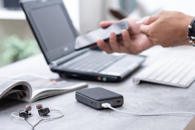 Güç bankasıyla çalışan akıllı telefon bataryası. Gri güç bankasına yakın plan.. 