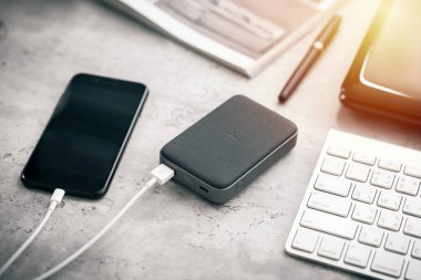 Güç bankasıyla çalışan akıllı telefon bataryası. Gri güç bankasına yakın plan.. 