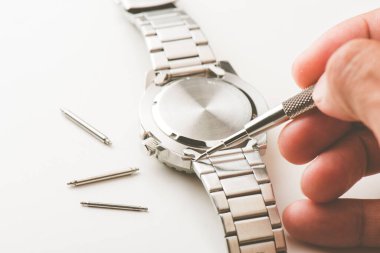 Bahar barı aletini kullanan bir saatçi. Yay çubuklarını kaldırmak için kullanılan yay çubuğu aracı saat kayışını değiştirmek için.