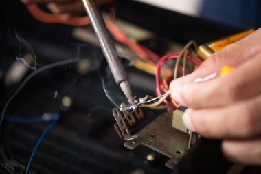 Elektronik cihazı tamir etmek için lehim makinesi kullanan teknisyen..