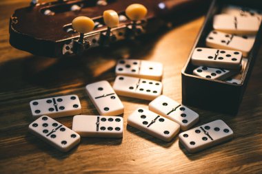 Masadaki Domino fayanslarını kapatın. Domino en ünlü klasik oyunlardan biridir. Düşük ışık ve sığ alan derinliğinde çekim.