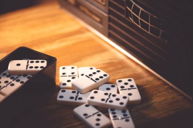 Masada bir yığın Domino taşı var. Domino en ünlü klasik oyunlardan biridir. Düşük ışık ve sığ alan derinliğinde çekim.