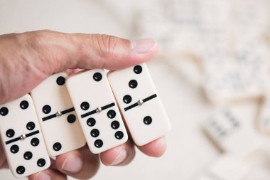 Domino taşlarını elinle kapat. Dominolar en ünlü klasik oyunlardan biridir..