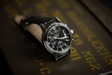 Siyah deri saat bandıyla askeri kol saatini kapat. Arka planda askeri nesneler olan erkekler için kol saati.