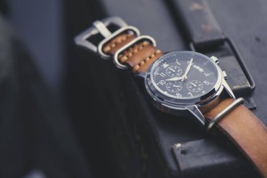 Deri saat bandıyla askeri kol saatini kapat. Arka planda askeri nesneler olan erkekler için kol saati.