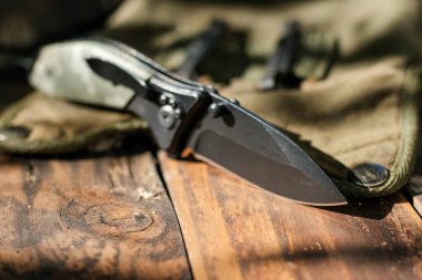 Ahşap masada paslanmaz çelik çakı. Katlanan bıçak her gün taşır.