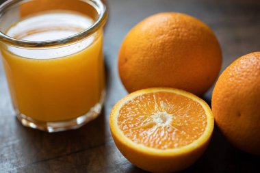 Ahşap bir masada bir bardak portakal suyu ve portakal. Arkaplan. 