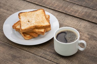 Masada bir fincan sade kahve ve kızarmış ekmek.