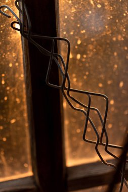 Günbatımında pencere ve tel olan soyut bir sahne. Yakın plan. Evet.