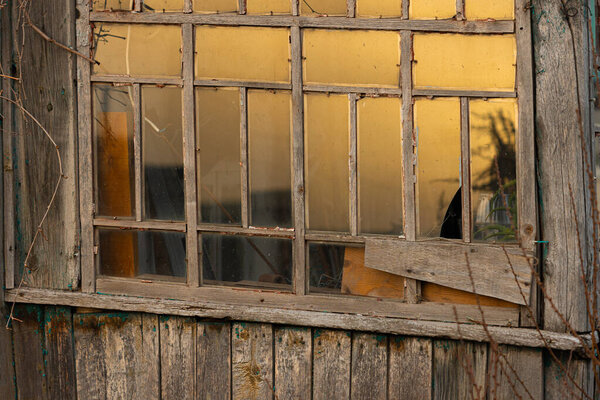 The window of the old house reflects the golden sunset light