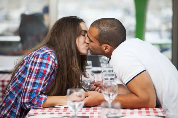 Couple kissing at the restaurant table