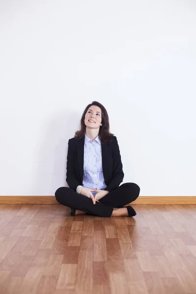 Businesswoman sitting on the floor of an empty room