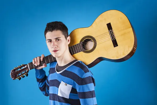 Teenager Κρατώντας Μια Κλασική Κιθάρα Μπλε Φόντο Εικόνα Αρχείου