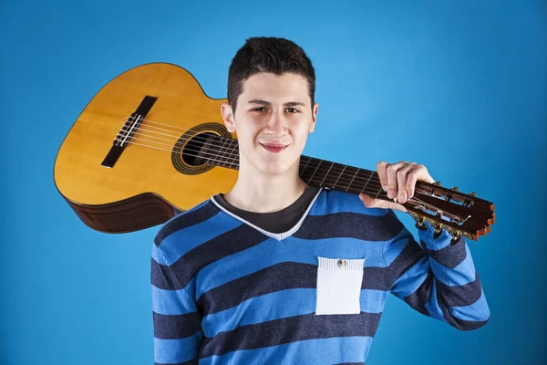 Tonåring Som Håller Klassisk Gitarr Med Blå Bakgrund Stockbild