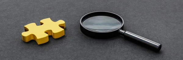 Lupe Und Ein Gelbes Puzzleteil Auf Dunklem Hintergrund Mit Kopierraum — Stockfoto