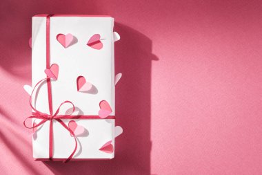 Gift in homemade wrapping paper with voluminous hearts. View from above. Copy space.