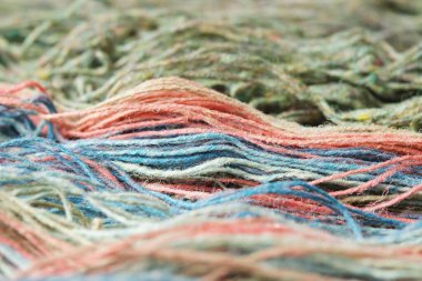 Doğal organik koyun yününden iplikler. Yakın plan, makro. İki yarasız yeşil ve gökkuşağı örgü ipliği..