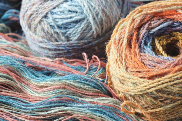 来自天然有机羊毛的纱线 两个多色毛线球和一卷未捻的彩虹纱 — 图库照片