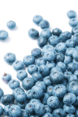 Fresh blueberries scattered on a white background.