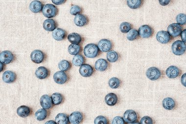 Fresh blueberries scattered on a linen napkin.