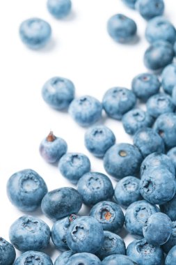 Fresh blueberries scattered on a white background.