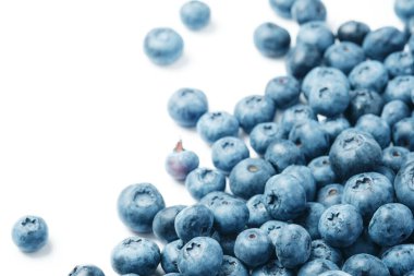 Fresh blueberries scattered on a white background.