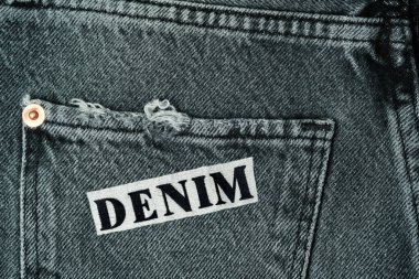 Siyah kotun arkasında, cebinde nakışlı DENIM harfleri var.,