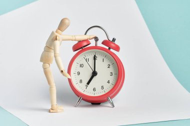 Tahta adam eli çalar saatin üzerinde duruyor. Sabah kalktığında, günün başında..