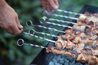 Domuz barbeküsü pişiriyorum. Erkek elleri etle şişlenir..