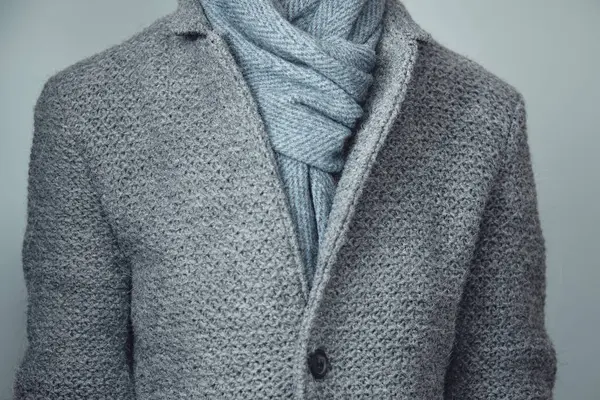 Gri örgü ceket ve mavi eşarp yakın plan. Kış, sonbahar sıcak yün giysiler.