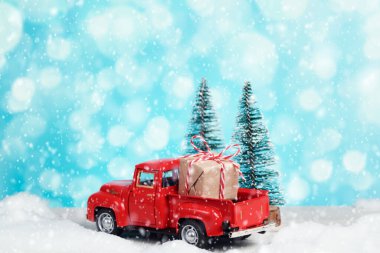 Hediyesi olan kırmızı oyuncak kamyonet. Mutlu Noeller ve yeni yıl selamlar, boks günü, teslimat.