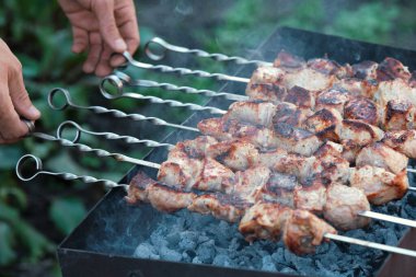 Domuz barbeküsü pişiriyorum. Erkek elleri etle şişlenir..