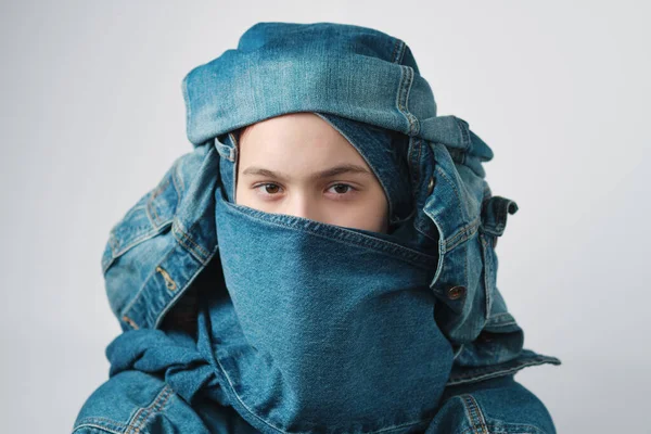 Sarık gibi bir kot başlık giyen bir kızın portresi. Kot pantolon, kot pantolon..