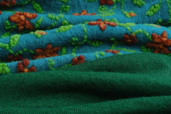 Crafted Felt Fabric. Textured Wool Landscape. Close-up of green and blue wool fabric with red flowers.