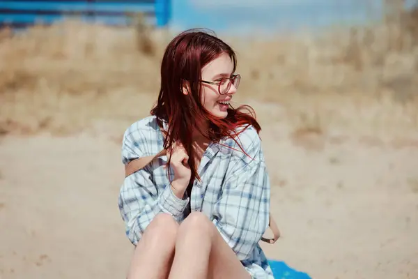 Plajda gülümseyen gözlüklü genç kız Z neslinin canlı ruhunu temsil ediyor, güneşli bir gün, neşeli bir ifade..